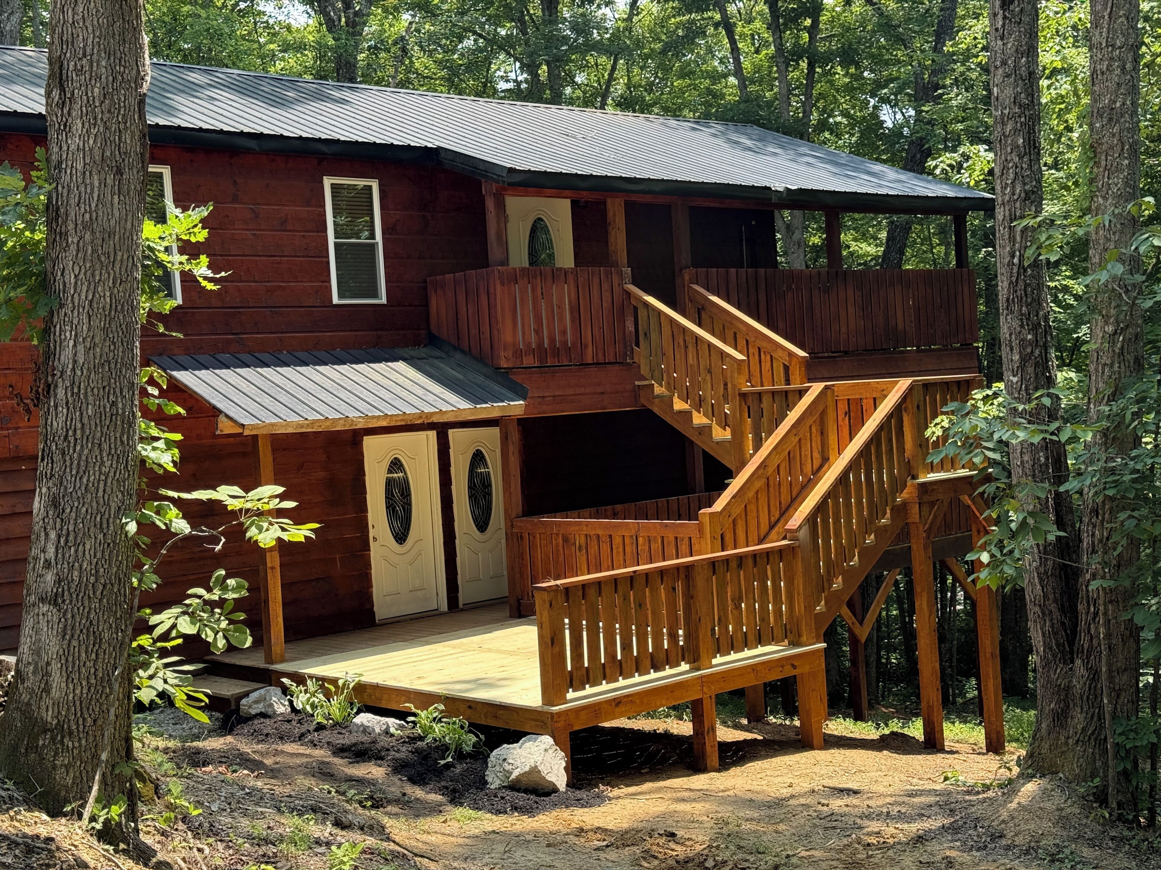 Une cabane dotée d’une terrasse en bois et d’un escalier menant à un niveau supérieur.