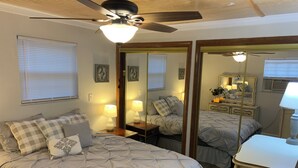 A bedroom with a bed, a nightstand, a dresser, a mirror, and a ceiling fan. -  JC'S Place #3 (Hebron)