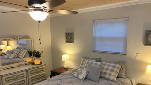 A bedroom with a bed, a dresser, a nightstand, a ceiling fan, a window with blinds, and a wall-mounted mirror. -  JC'S Place #3 (Hebron)