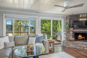 Un salón amplio con chimenea, ventanas grandes y vistas al exterior.