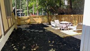 A backyard with a wooden deck, a raised garden bed, and outdoor furniture.