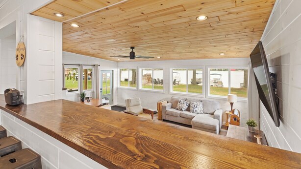 Una cocina amplia con techo de madera, ventanas grandes y una zona de bar moderna.