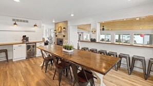 Una cocina moderna con una isla central, armarios blancos y vistas al exterior.