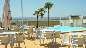 A poolside area with white chairs and umbrellas, a clear view of the beach, and a pool. - Perfectly located apartment. Close to the town and the beaches. (Fuseta)