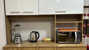 A kitchenette with white cabinets, a wooden countertop, a blender, a kettle, and a microwave. - Comfortable/Cozy SKY HOUSE CUSCO (CUSCO)