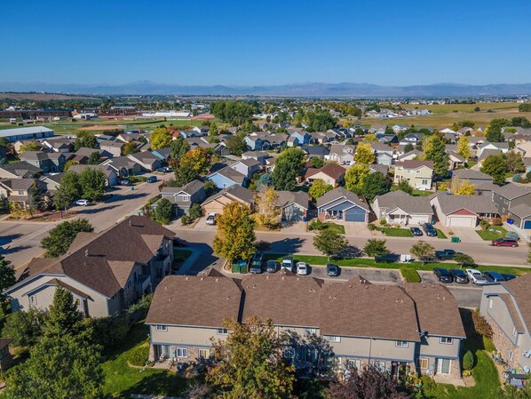 Un quartier résidentiel avec des maisons, des rues et une chaîne de montagnes visible au loin.