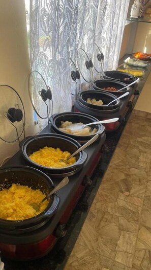 Un buffet proposant une variété de plats présentés dans différents récipients.