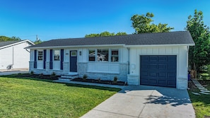 A single-story house with a front porch, a garage, and a well-maintained lawn.