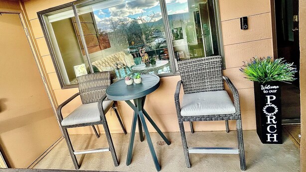 A patio with wicker chairs, a round table, and a potted plant. - Charming Red Rock Poolside Condo with WiFi, AC in superb Sedona (Sedona)