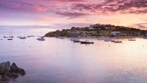 A coastal marina with boats docked, calm water, and a hillside with buildings. - Studio Double @ WorldMark Elysian Beach Resort (St Thomas)