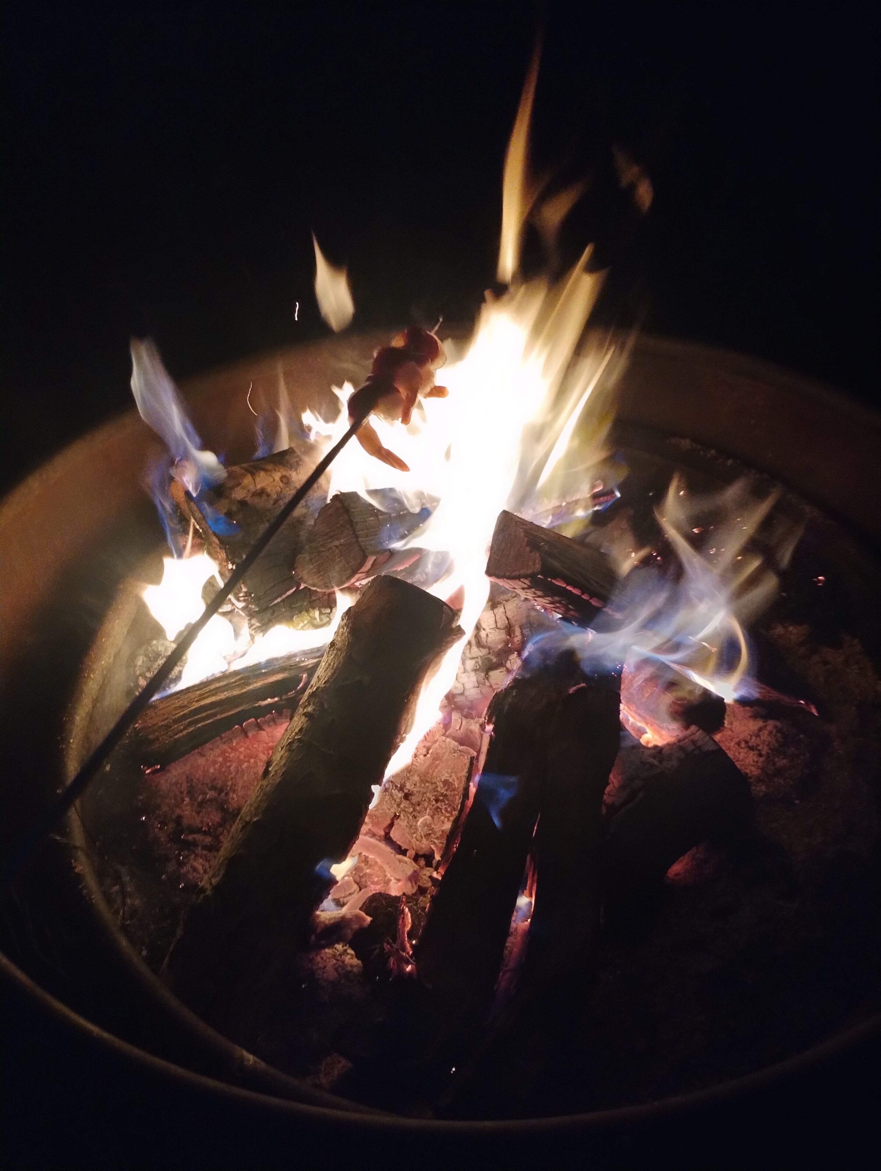 A close-up of a campfire with logs and flames.