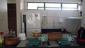 A kitchen with a refrigerator, a sink, and a window. - Cozy in Calhau near the coast  (Calhau São Luís)