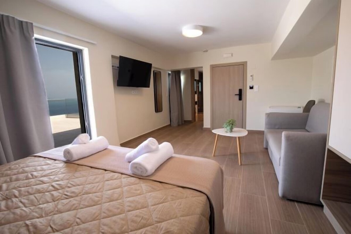 Ett hotellrum med en säng, en soffa, en tv och ett litet bord.
