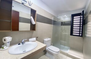 Enjoy a refreshing shower in the spacious bathroom with a sink, toilet, and glass-enclosed shower area.