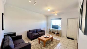 A living room with a sofa, a coffee table, and a TV stand.
