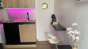 A compact kitchen with a wooden countertop, a sink, and a small island with a pink-lit under-cabinet. - Cosy studio Cannes, France, 250 meters from the beach, Pointe Croisette (Cannes)