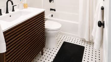 A modern bathroom with a sink, toilet, and shower.