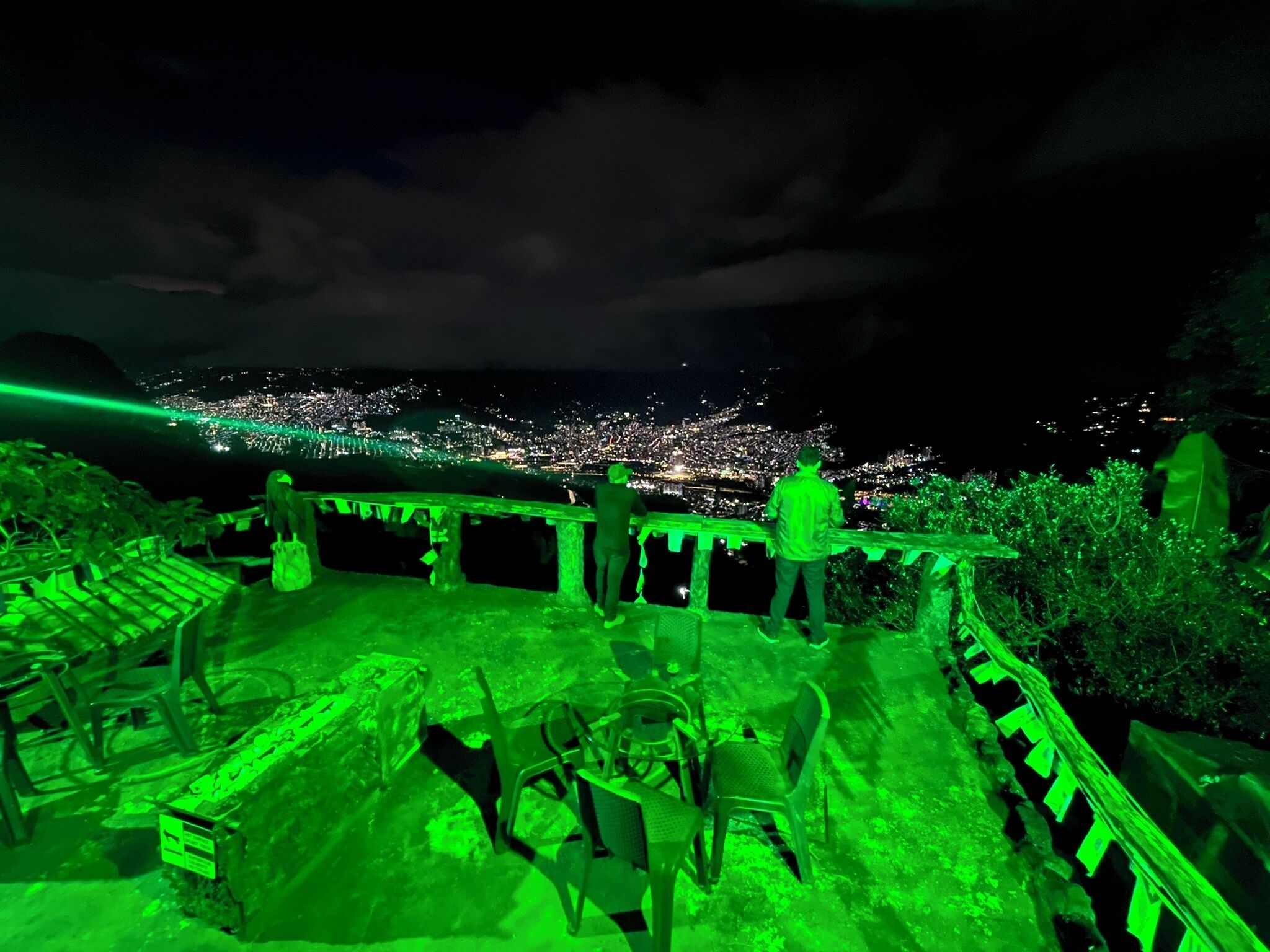 Una terraza en la azotea con vistas a un paisaje urbano nocturno.