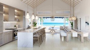 A spacious kitchen with a large island, modern appliances, and a view of the beach. - NEW BluWakes #2 5BR Beachfront Villa/Pool/Luxury (George Town)