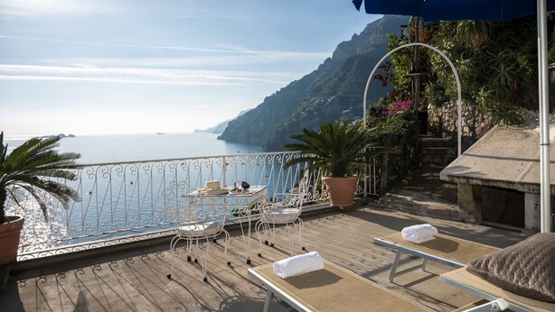 A wooden deck with lounge chairs, a table, and a potted plant. - Estate4home- Casetta Arienzo (Positano)