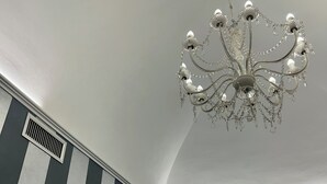 Ein Raum mit einer Chandelier, Streifenwänden und einer Tür.