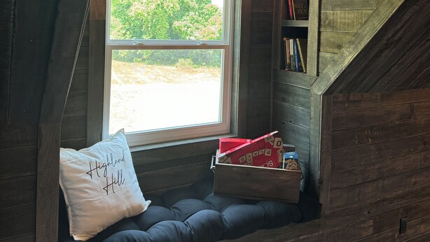 A cozy attic bedroom with a built-in window seat, a bookshelf, and a lantern. - Charming barn in Glasgow, modern amenities, private setting close to downtown (Glasgow)
