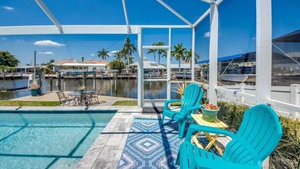 A pool area with turquoise chairs and a view of a marina. - Entire home in Matlacha Isles-Matlacha, Florida
4 guests 2 bedrooms 3 beds (Matlacha Isles-Matlacha Shores)