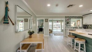 A modern kitchen with a wooden dining table and bar stools, a large mirror, and a view into the living area. - Entire home in Matlacha Isles-Matlacha, Florida
4 guests 2 bedrooms 3 beds (Matlacha Isles-Matlacha Shores)
