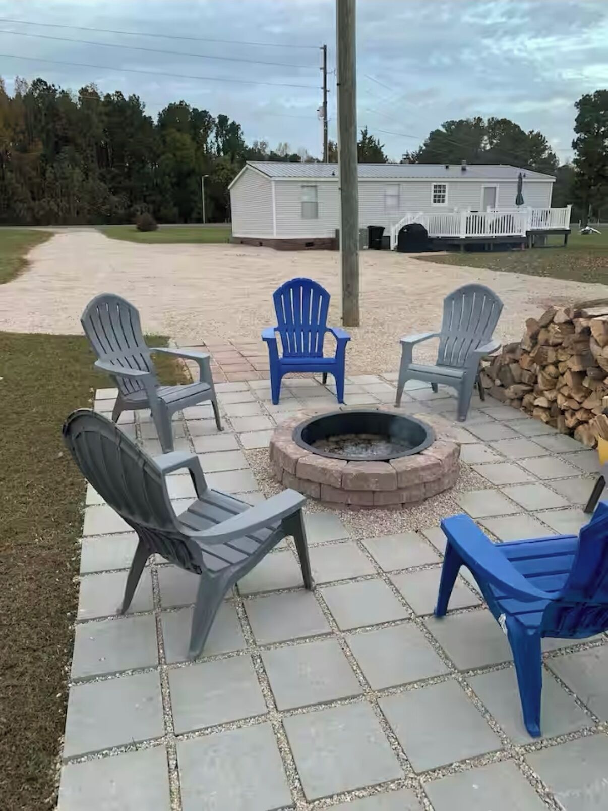 Un espace patio avec un foyer entouré de fauteuils Adirondack.