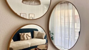 Three round mirrors on a wall, reflecting a room with a sofa, a table, and a hanging light fixture. - La Esterlicia (Los Abrigos)