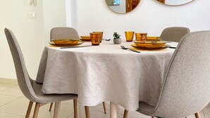 A dining area with a round table, grey chairs, and a white tablecloth. - La Esterlicia (Los Abrigos)