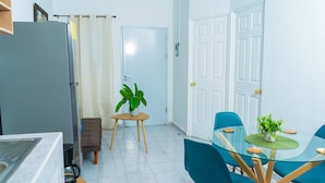 A modern kitchen with a refrigerator, a coffee maker, and a small table with a potted plant. - Casa Oriente (San Miguel)