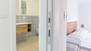 A bedroom with a bed, a bedside table, and a lamp. - Cerboli by Interhome (Follonica)
