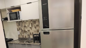 A modern kitchen with stainless steel appliances, a microwave, and a refrigerator. - Summer dream. Beach House: The Perfect Place to Relax and Enjoy! (Recreio dos Bandeirantes Rio de Janeiro)