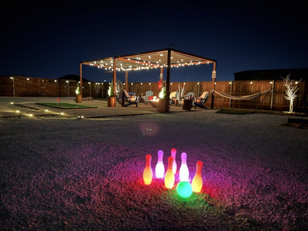 An outdoor area with a covered seating area and a bowling alley setup.