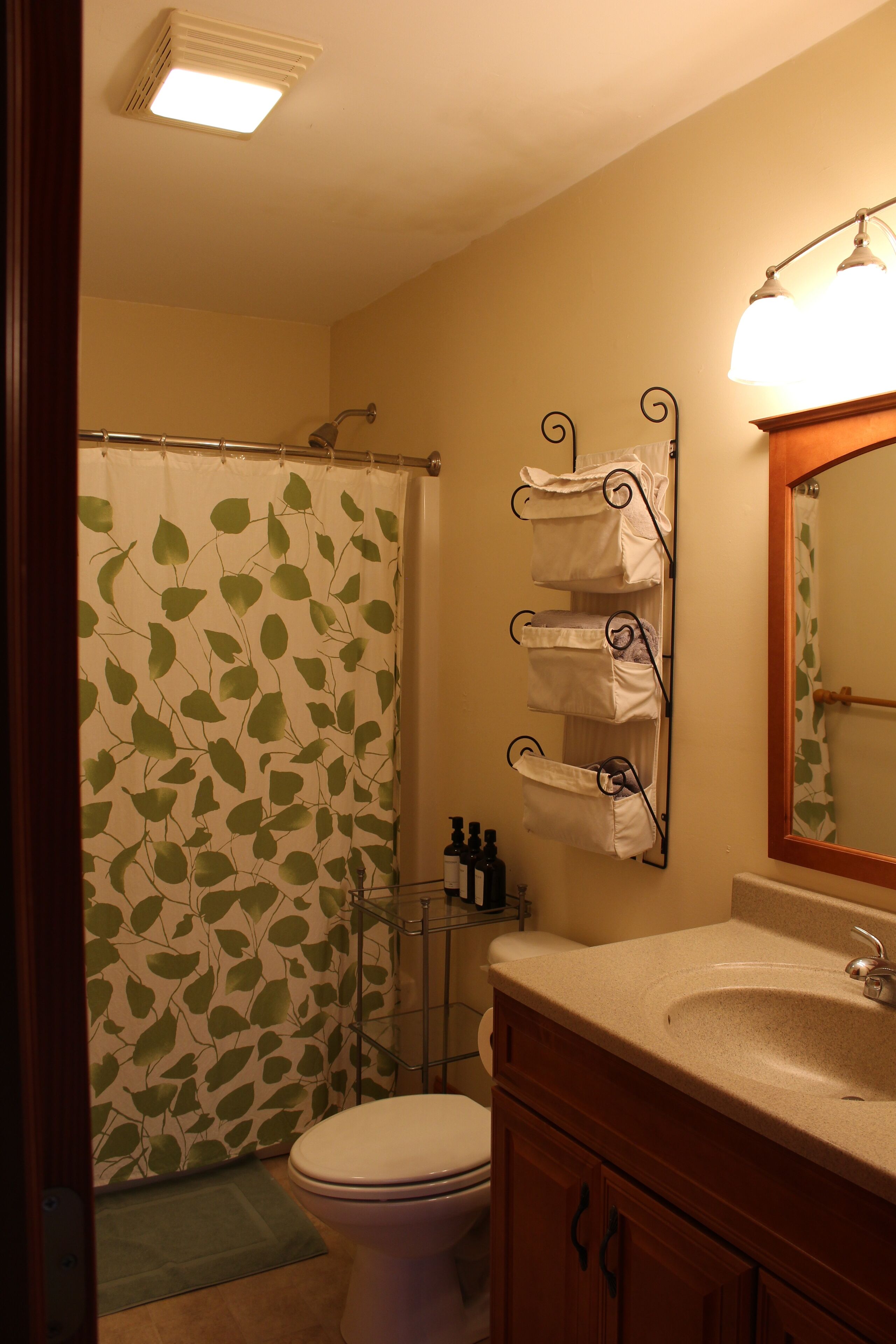 Une salle de bain équipée d’un rideau de douche, de toilettes, d’un lavabo et de porte-serviettes.