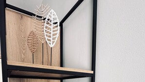 A multi-tiered wooden shelving unit with macramé decorations and a woven basket. - Luizas Apartments  (Sarandë)