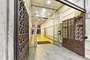 Ein Hotel Eingang mit Glastür, einem Metallgitter und einem gefliesten Boden.
