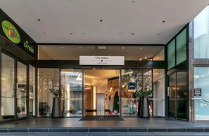 Welcome to The Sebel Auckland, featuring a modern entrance with a glass facade and a clear sign.