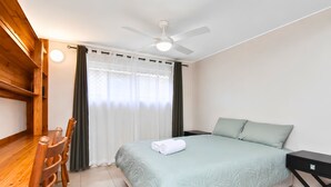 A hotel room with a bed, a desk, and a chair.