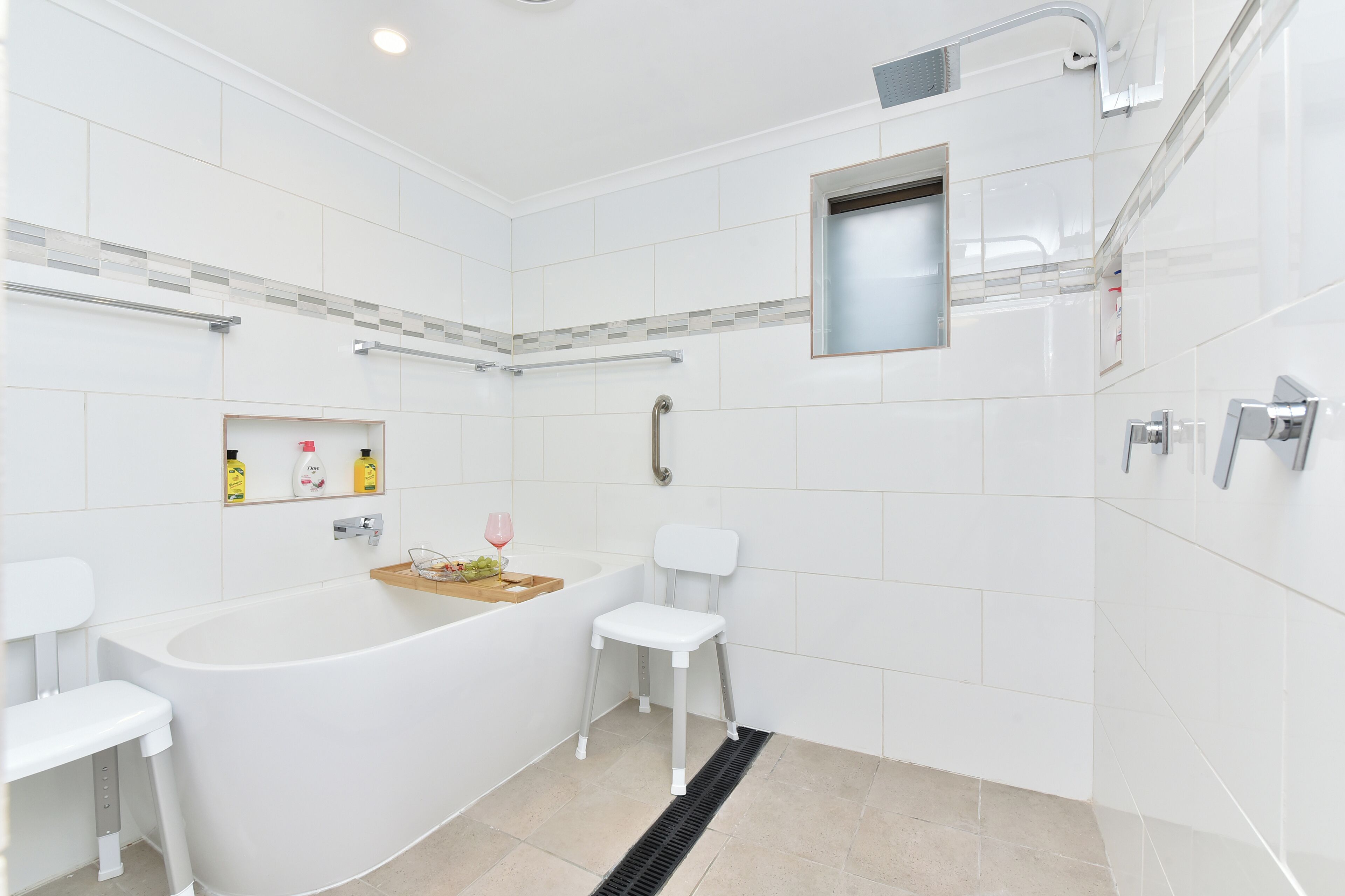 Un baño moderno con una bañera independiente, un inodoro blanco y una zona de ducha.