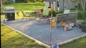 Un jardin avec un barbecue, du mobilier d’extérieur et un petit abri de jardin.