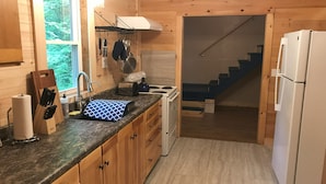 Una cocina compacta con armarios de madera, un lavamanos, una estufa y un refrigerador.