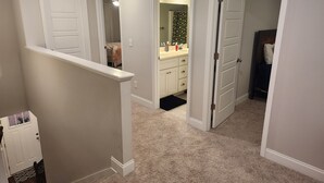 A hallway with carpeted floors, white walls, and doors leading to a bathroom and a bedroom. - Charming house just minutes to the Augusta National in fabulous North Augusta (North Augusta)