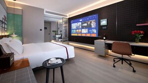A modern hotel room with a bed, a desk, a chair, a TV screen, and a small table with a cup and saucer. - lanziguojijiudian (Chongqing)