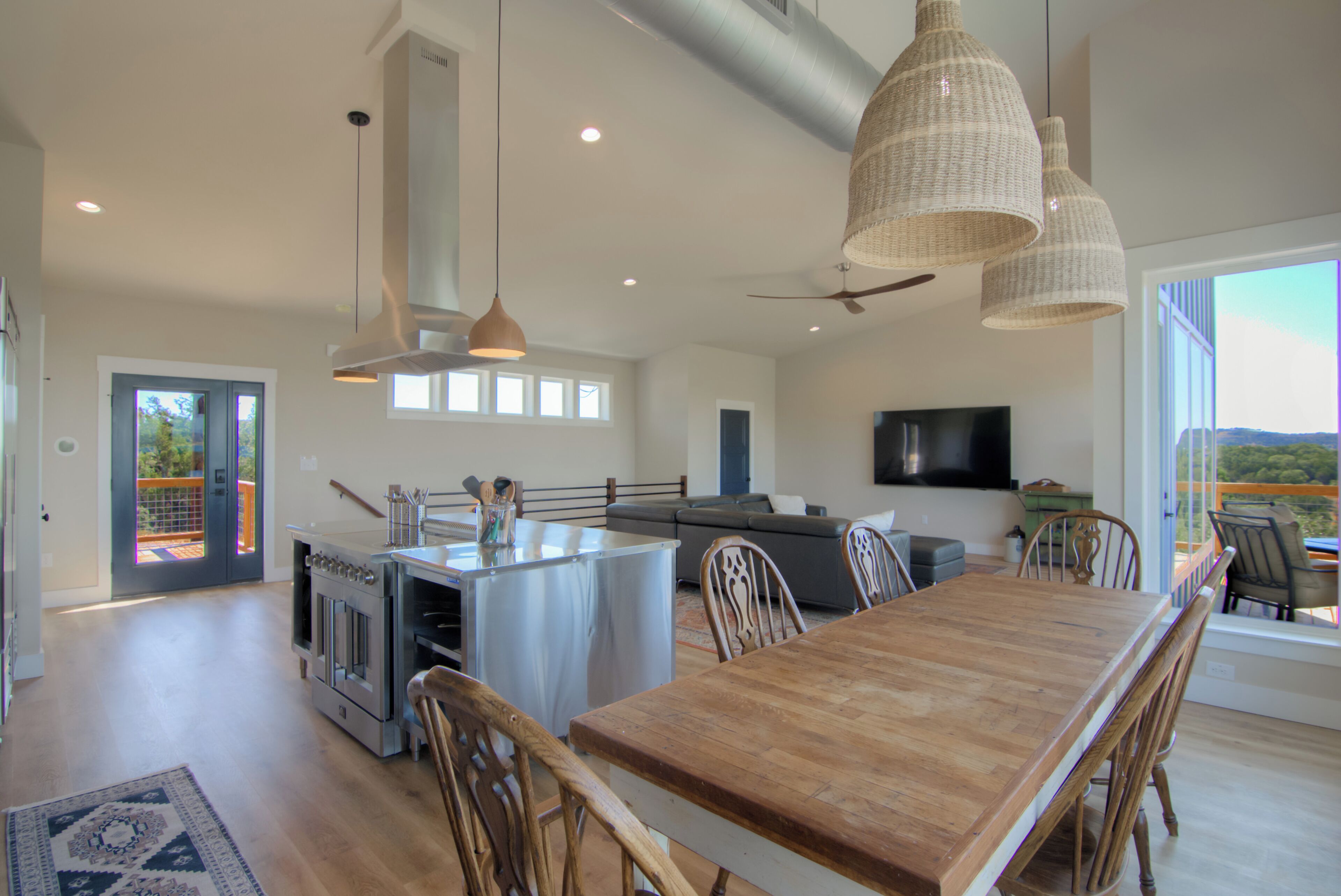 Una cocina amplia con una isla central, un comedor con mesa de madera y un ventanal con vistas.