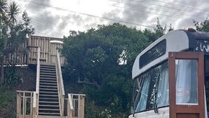 A bus parked on a wooden ramp leading to a wooden deck. - Luxury Beach Bus (Whanganui)