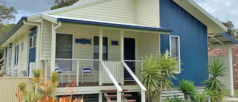 A two-story house with a covered porch and a small front yard.