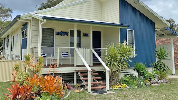 A two-story house with a covered porch and a small front yard.