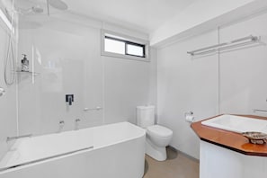 Un baño moderno con bañera, inodoro y ducha.